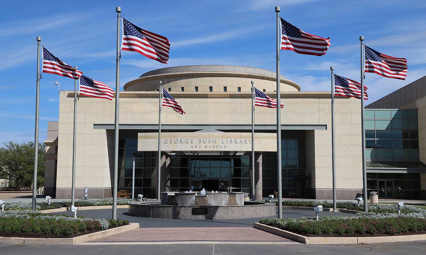 Eight American flags fly outside of the George Bush Library and Museum in College Station, Texas
