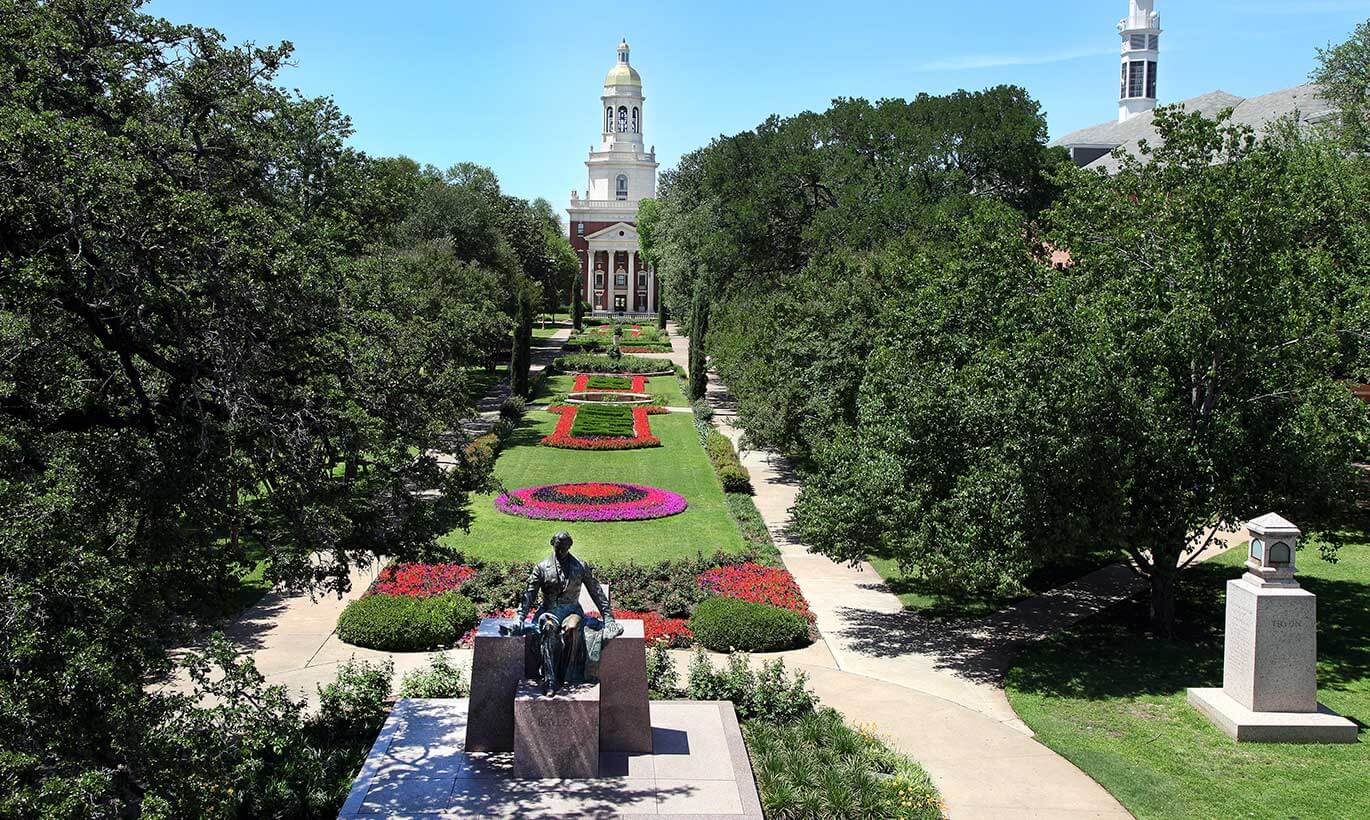 A green lawn with colorful flowers in front of Pat Neff Hall at Baylor University in Waco, Texas